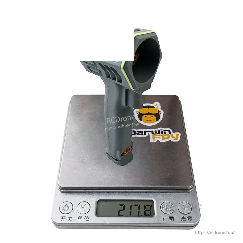 Gray handheld turbo fan shown on digital scale displaying 217.8 g weight
