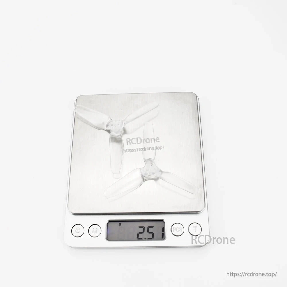 Two clear tri-blade propellers on digital scale showing 2.51 g reading