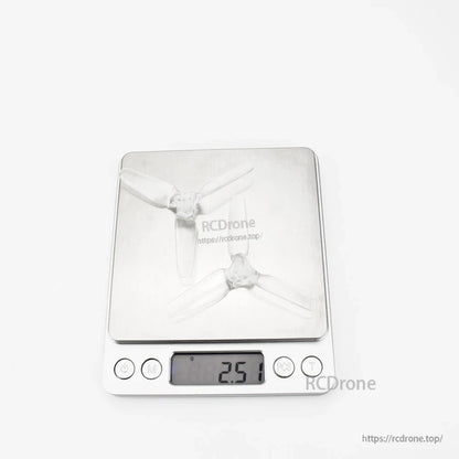 Two clear tri-blade propellers on digital scale showing 2.51 g reading