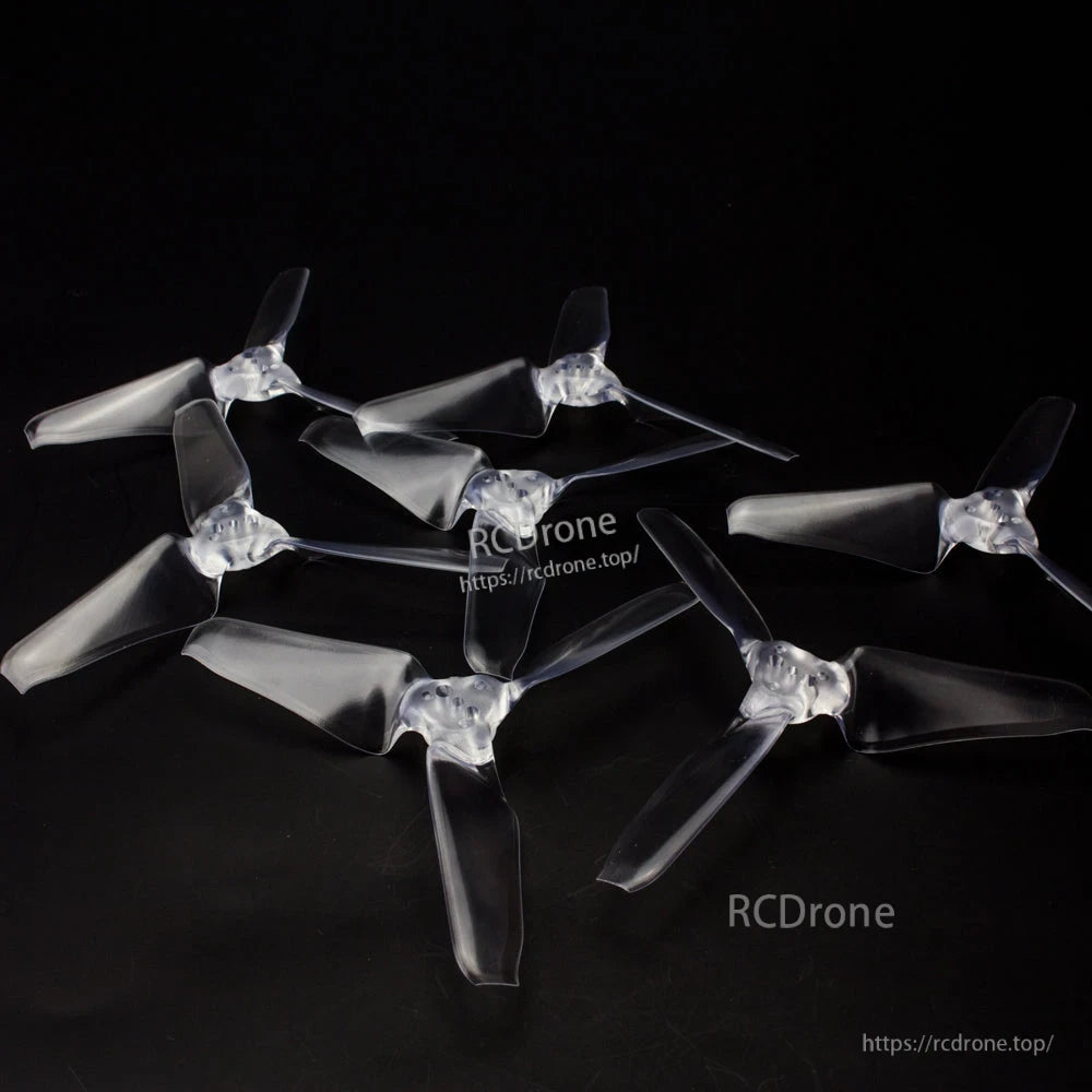 Set of clear tri-blade propellers arranged on black background, multiple pieces shown