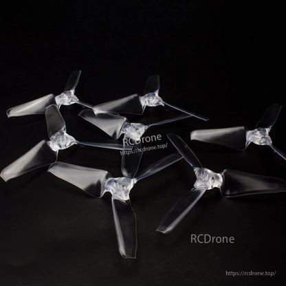 Set of clear tri-blade propellers arranged on black background, multiple pieces shown
