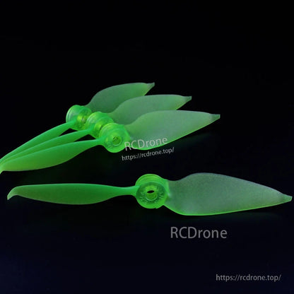 Neon green translucent 2-blade FPV racing propeller set, four stacked props plus one laid flat