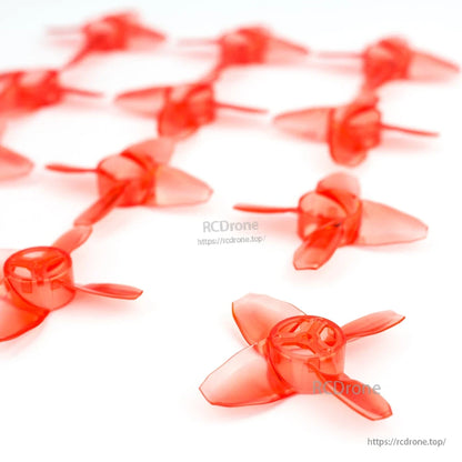 Low-angle close-up of translucent red 4-blade propellers showing hub and blade shape