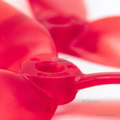 Close-up of red propeller hub with center mounting hole and molded 7040 marking