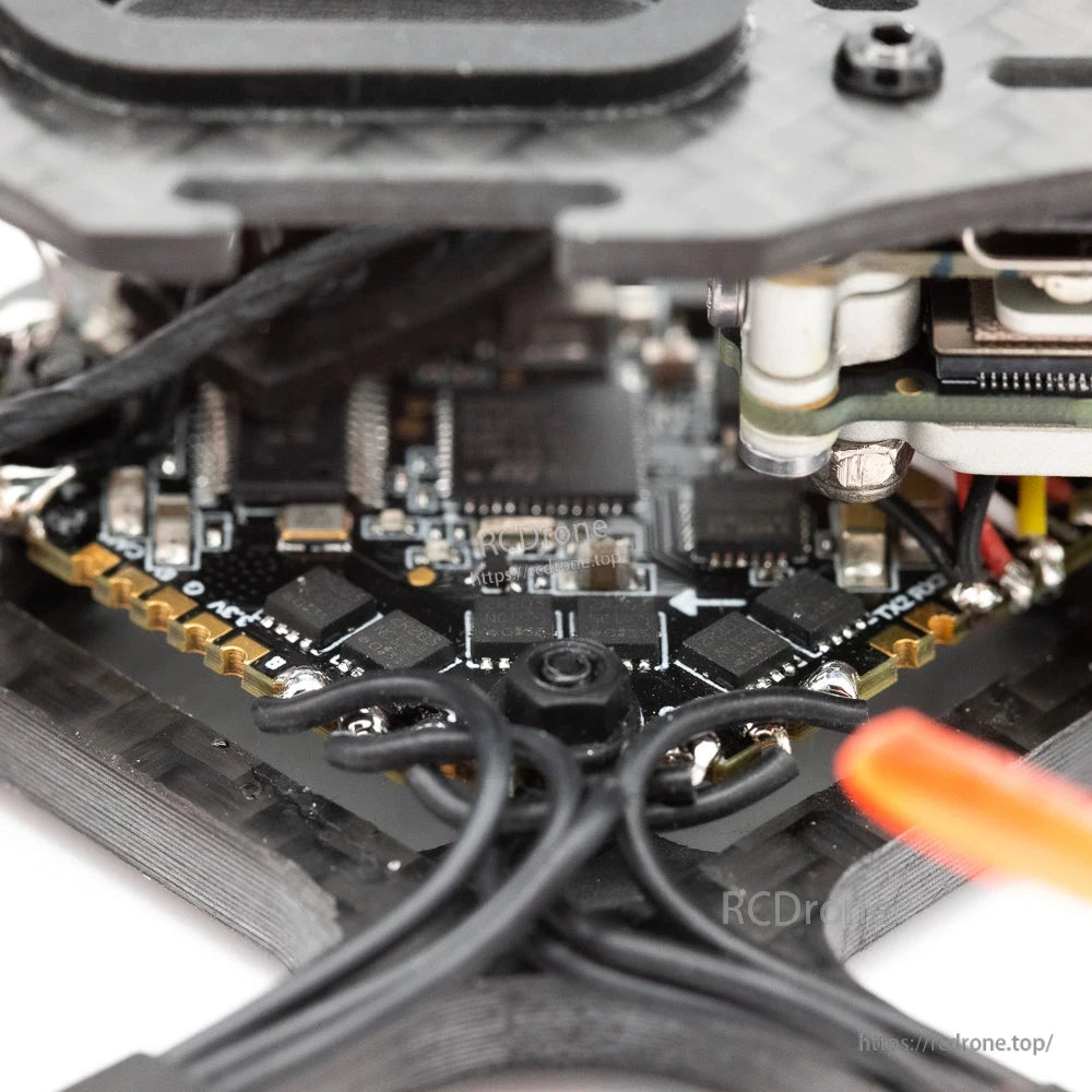 Close-up of flight controller/ESC stack and wiring inside the frame under the top plate