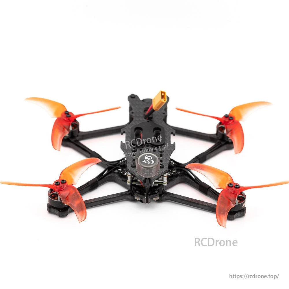 Rear view of micro FPV quadcopter showing antenna pod and orange tri-blade propellers