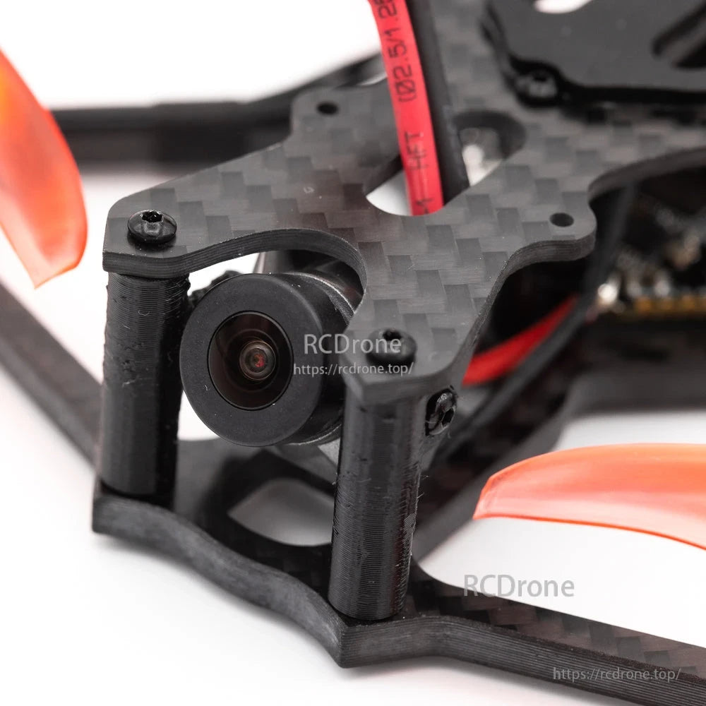 Close-up of front FPV camera mount on carbon frame with lens detail and standoffs