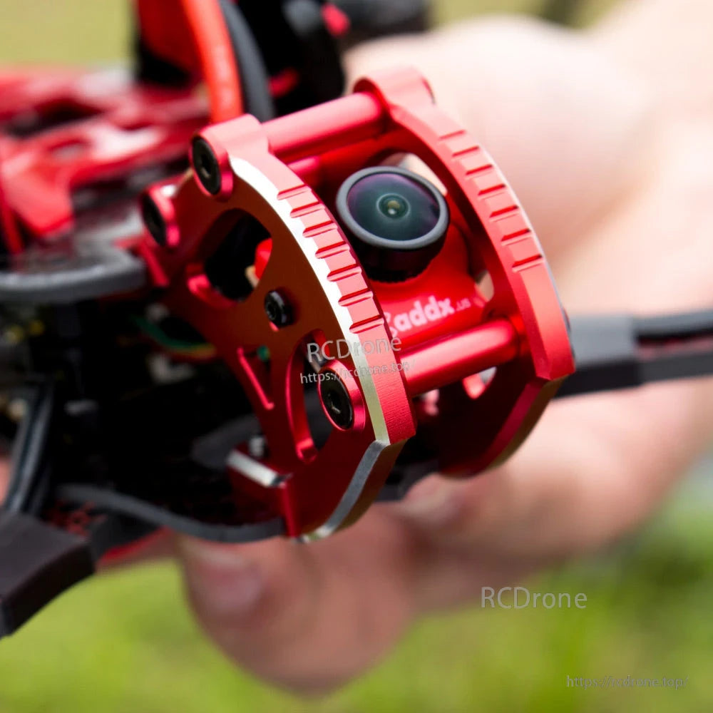 Close-up of FPV camera lens in red metal protective cage on the drone nose