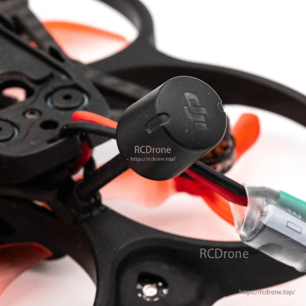 Close-up of rear-mounted FPV antenna on the drone with attached power lead and connector