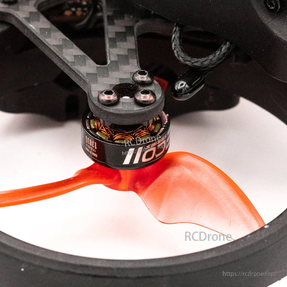 Close-up of brushless motor and carbon fiber arm with orange prop inside duct guard