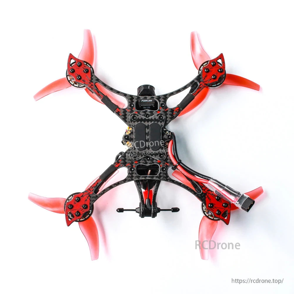 Top-down view of quadcopter showing carbon frame, red propellers, and central electronics stack
