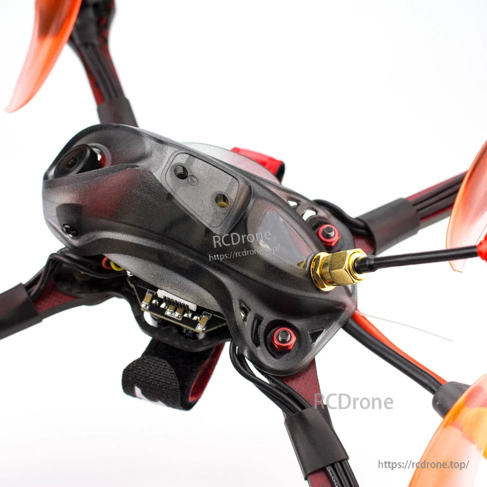 Close-up of top canopy showing FPV camera lens, mounting screws, and antenna connector on frame