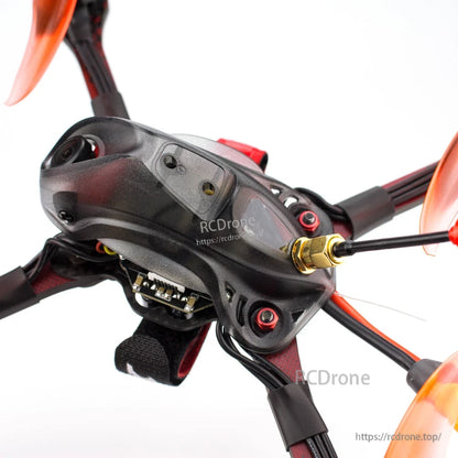 Close-up of top canopy showing FPV camera lens, mounting screws, and antenna connector on frame