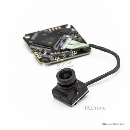 Camera lens front view with compact FPV camera housing and VTX board blurred behind