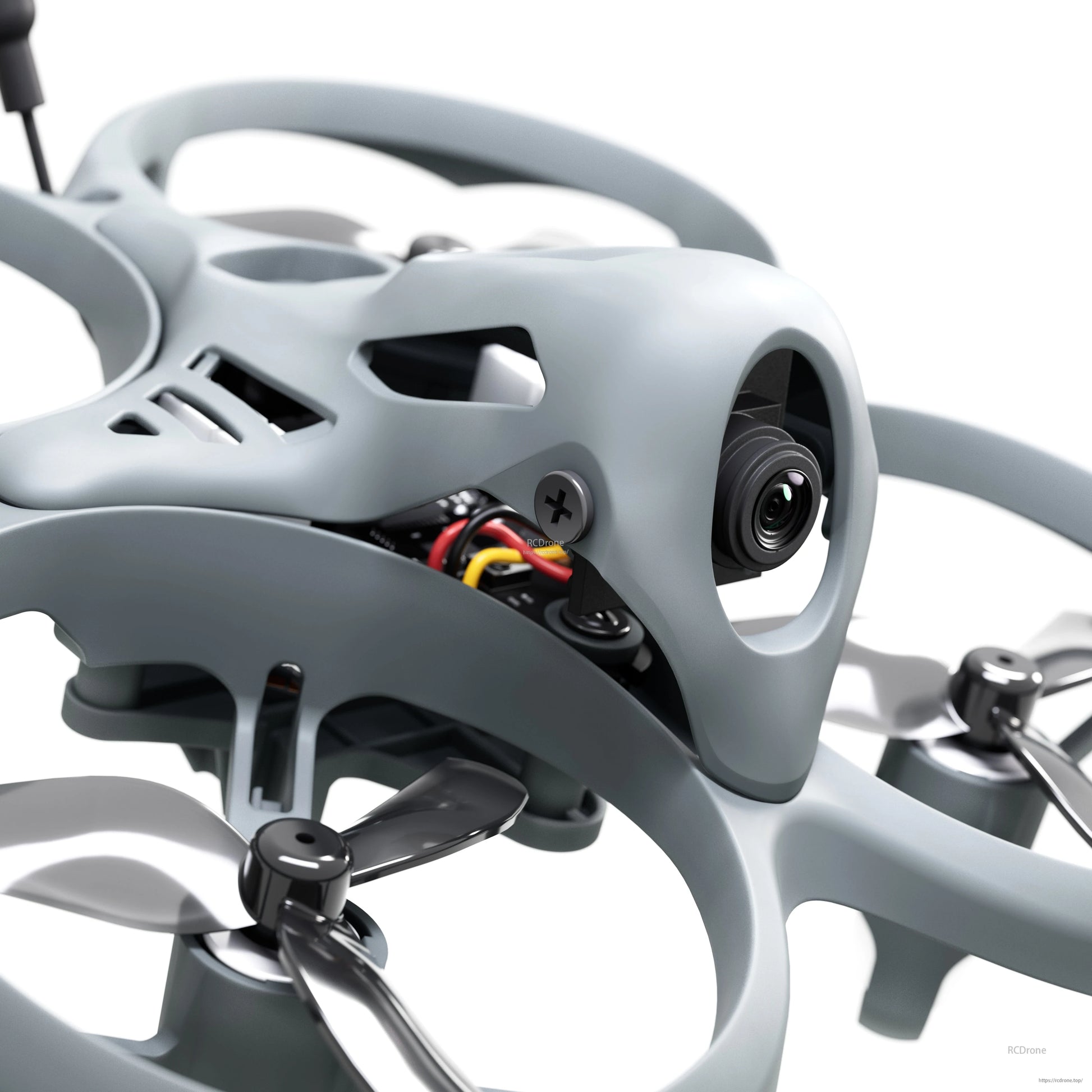 Close-up of FPV camera housing on micro whoop drone with exposed wiring under canopy