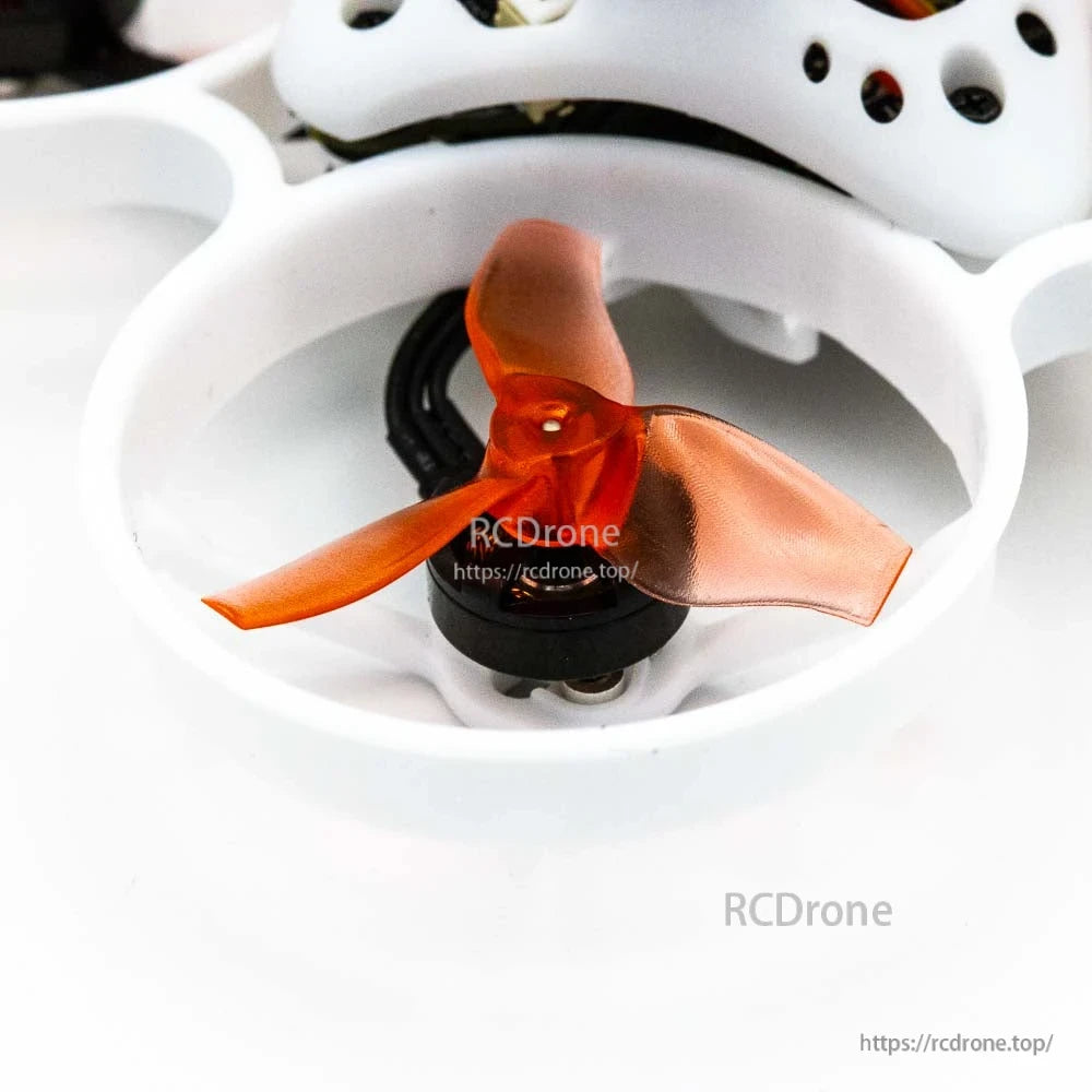 Close-up of orange tri-blade propeller and micro motor inside white duct guard