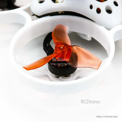 Close-up of orange tri-blade propeller and micro motor inside white duct guard