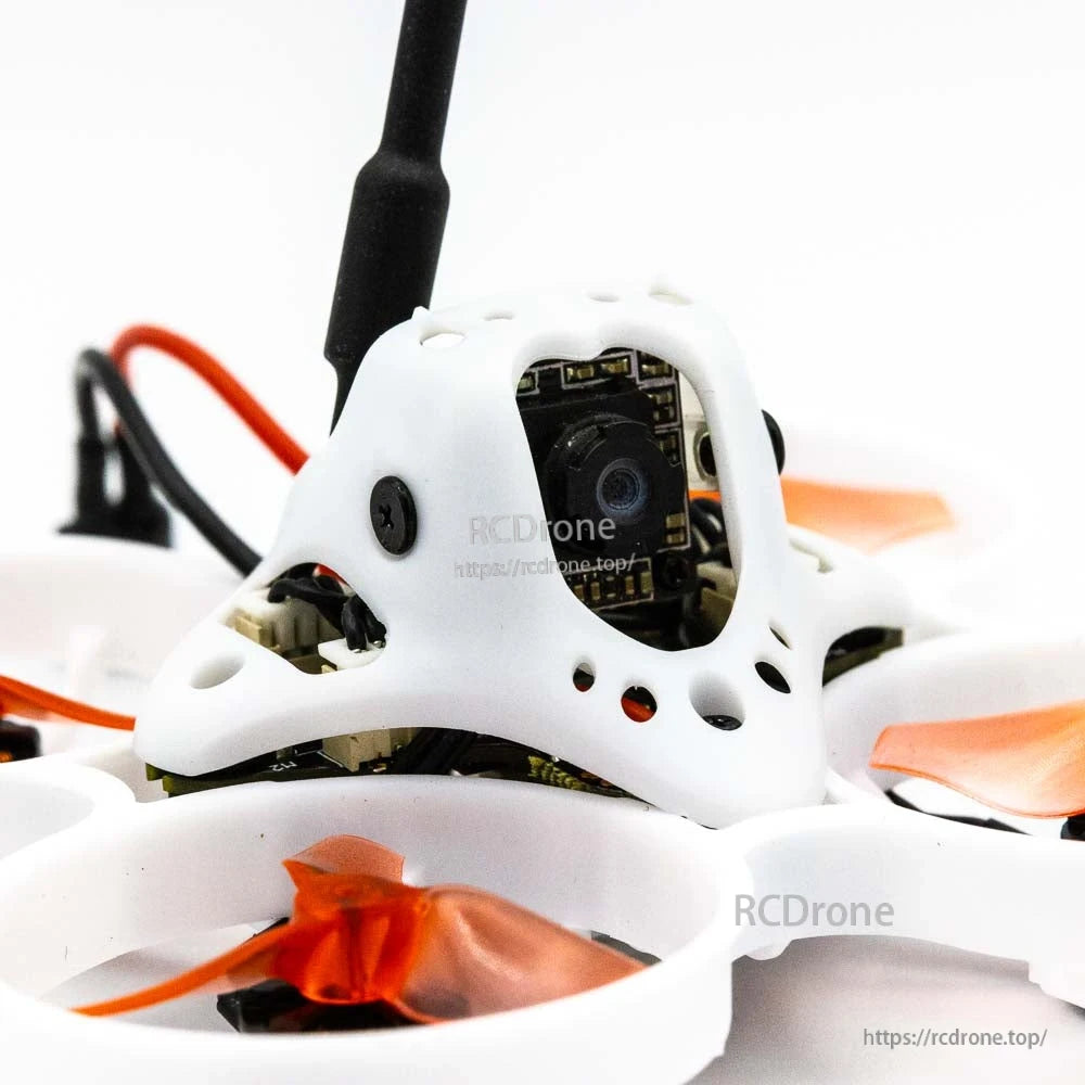 Close-up of FPV camera mounted in white canopy on micro whoop frame
