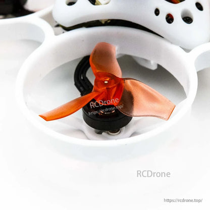 Close-up of orange three-blade propeller inside white duct with motor and wiring