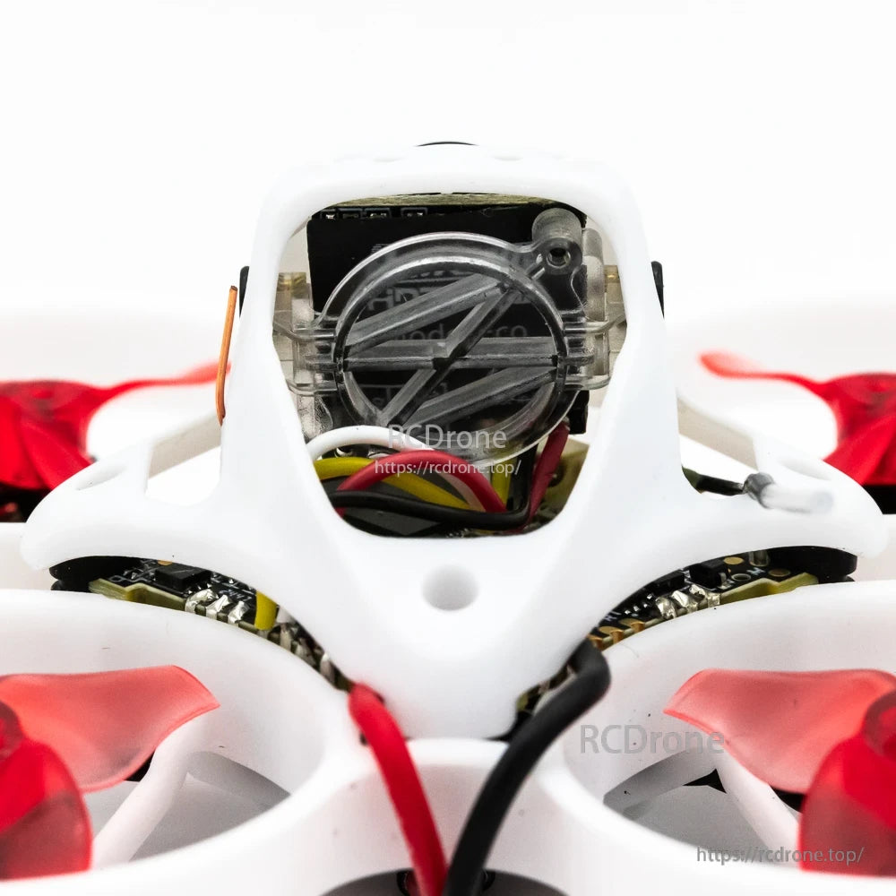 Close-up of camera module inside white canopy on 65mm whoop drone with visible wiring