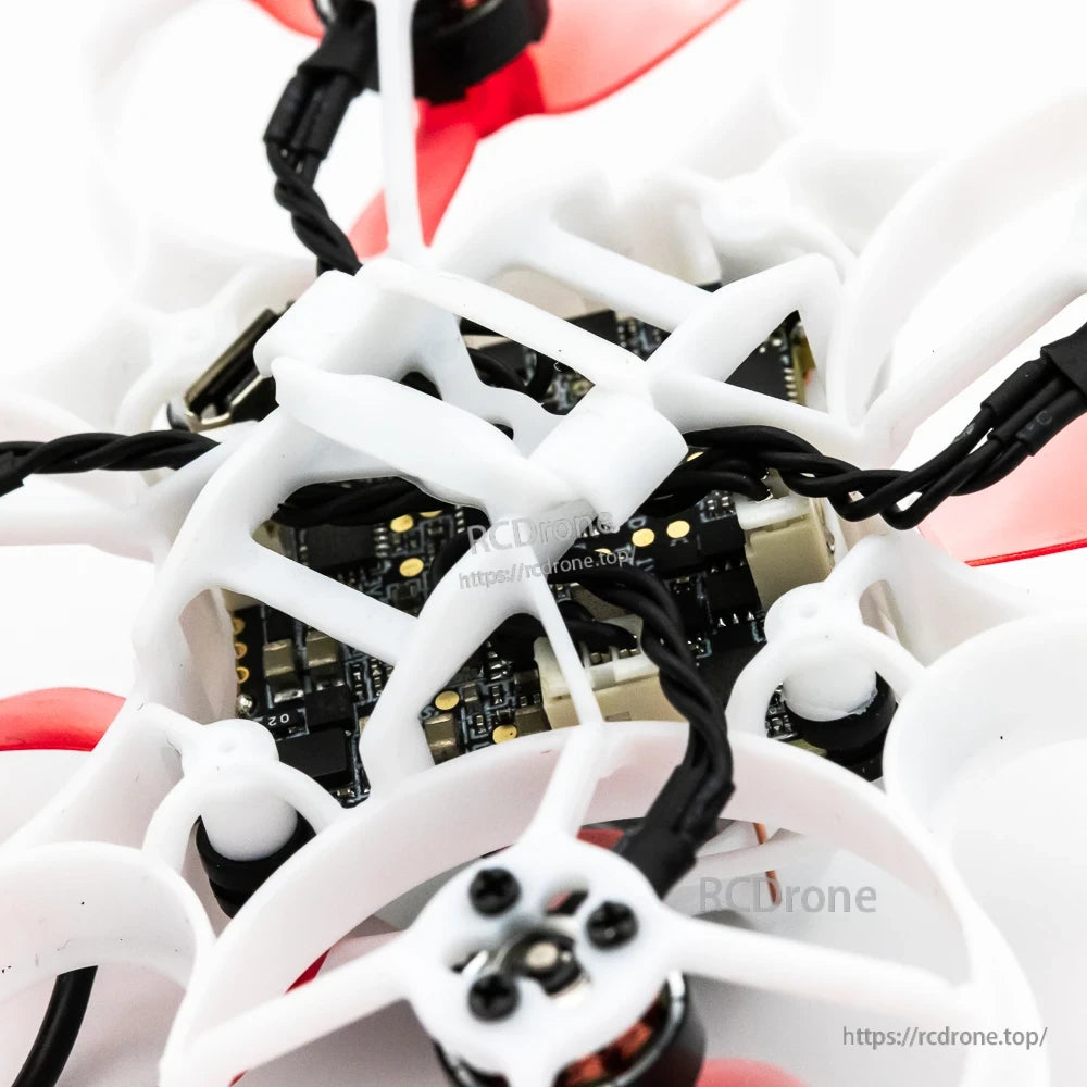 Top-down close-up of flight controller and wiring inside 65mm ducted whoop frame