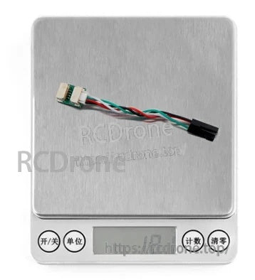 Adapter cable and small PCB placed on a digital scale to illustrate compact, lightweight inline design