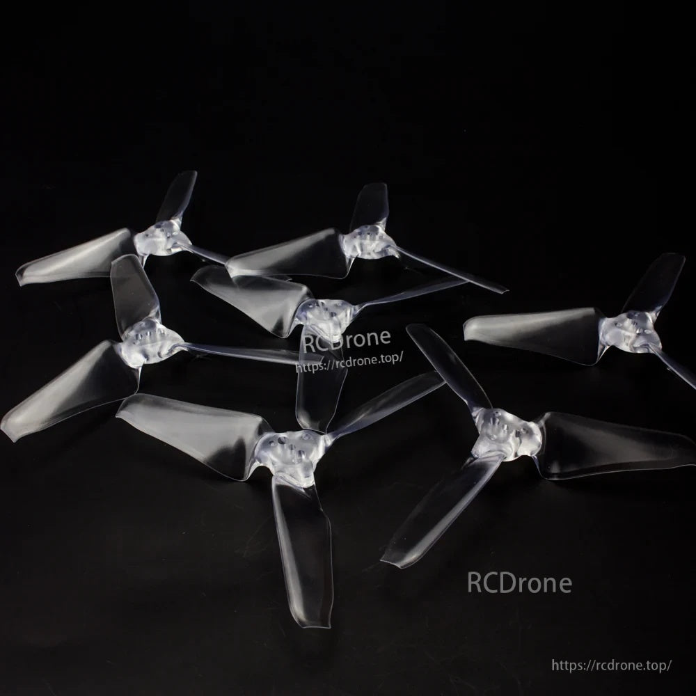 Clear AVAN Mini 3-inch tri-blade propellers arranged as a set on dark background