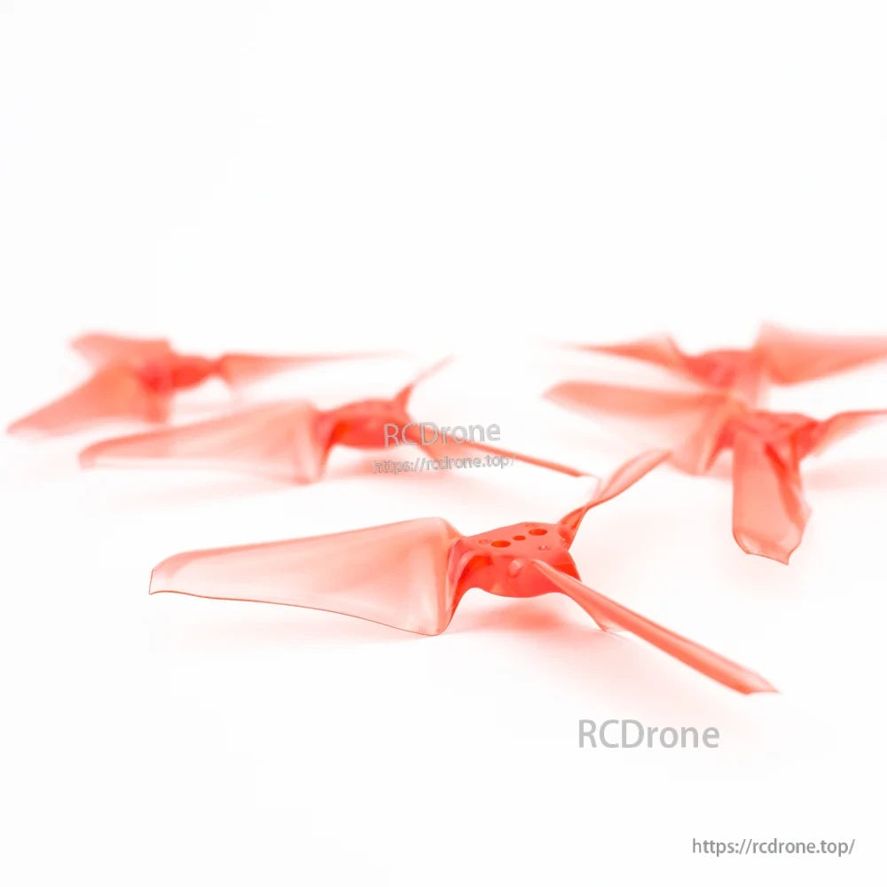 Low-angle close-up of red AVAN Mini 3-inch tri-blade propellers with reinforced hub and blade roots