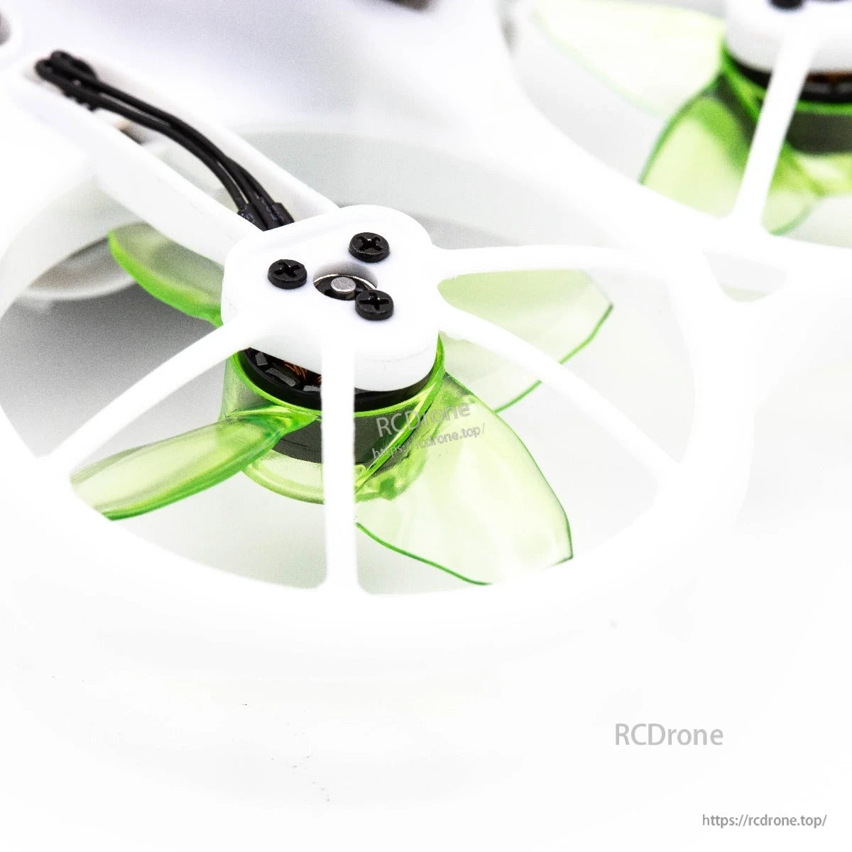 Close-up of green 4-blade prop mounted in duct, showing hub screws and motor area