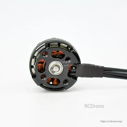 Bottom view of motor showing mounting base, bearing hub, copper windings and attached power wires