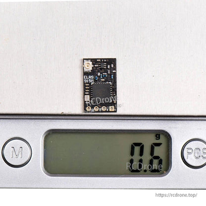 ELRS 915H receiver board on digital scale showing 0.6 g weight