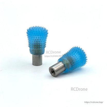 Blue spiked thumb stick ends pair on white background, one showing threaded metal opening