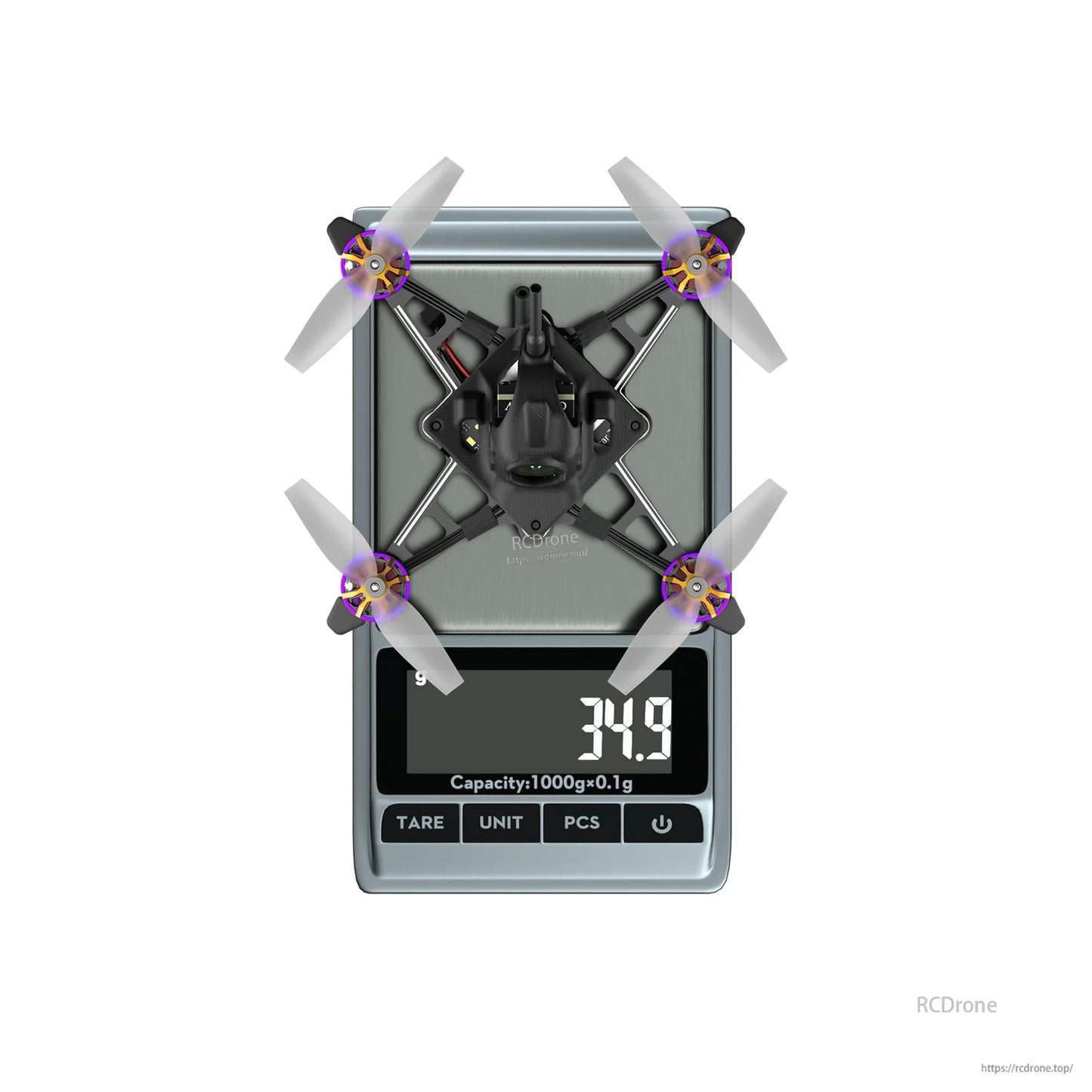 Tiny quadcopter drone with four propellers on a digital scale showing 34.9 g weight reading