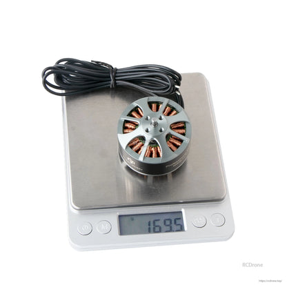 Flashhobby 4114 brushless DC motor with long lead wires on a digital scale showing 169.5 g