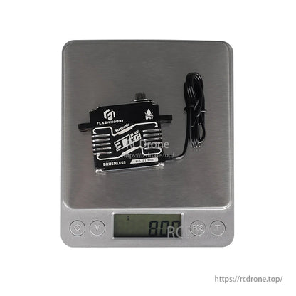 Flashhobby BLS3837MED Servo, Flashhobby BLS3837MED brushless servo on a digital scale, showing about 80 g weight with attached lead