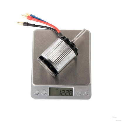 Flashhobby H550 1220KV helicopter motor with bullet leads and shaft, resting on a digital scale reading 12.28 oz