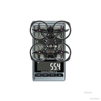 Flylens 75 HD O4 Wide 2S whoop FPV drone with ducted prop guards on a scale reading 55.4g