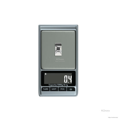 Flywoo Nano Black Box OpenLager module PCB on a digital scale, showing 0.4 g weight