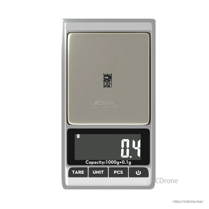 Tiny Flywoo 3.3V 1.5A BEC power module on a digital scale, weighing 0.4 g