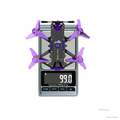 Flywoo Firefly 20PRO micro FPV quadcopter with purple props on a digital scale reading 99.0 g