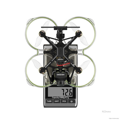 Flywoo FlyLens 85 HDZero whoop FPV drone on a digital scale, top view with ducted prop guards and 72.6g reading