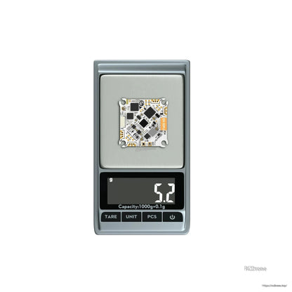 Flywoo GOKU F405 HD AIO flight controller board on a digital scale showing 5.2g weight
