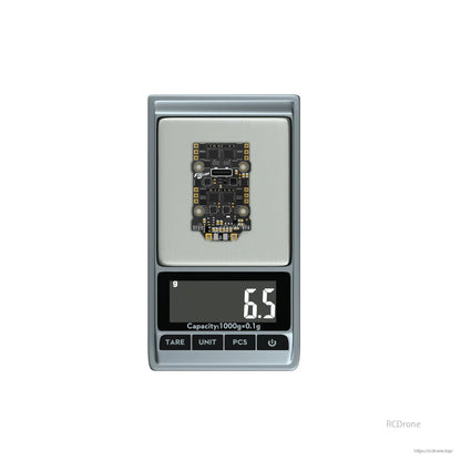 Flywoo GOKU F405 SE AIO flight controller and 4-in-1 ESC board on digital scale reading 6.5 g