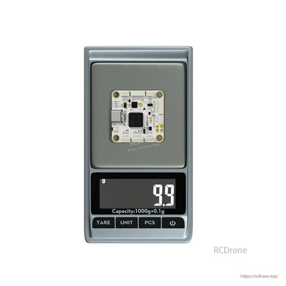 Flywoo GOKU F722 PRO V2 30x30 flight controller on a digital scale reading 9.9 g, compact white PCB with 30 mm mounting holes.