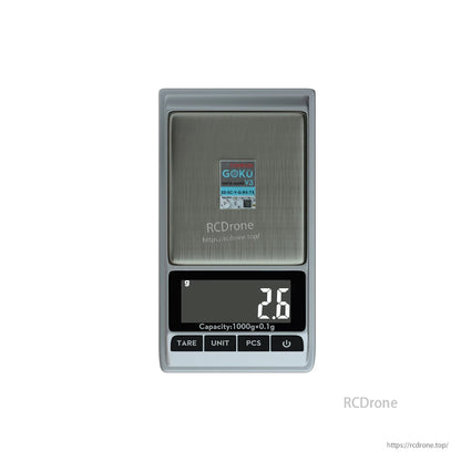 Flywoo GOKU GM10 Nano V3 GPS module on a digital scale, weighing 2.6g