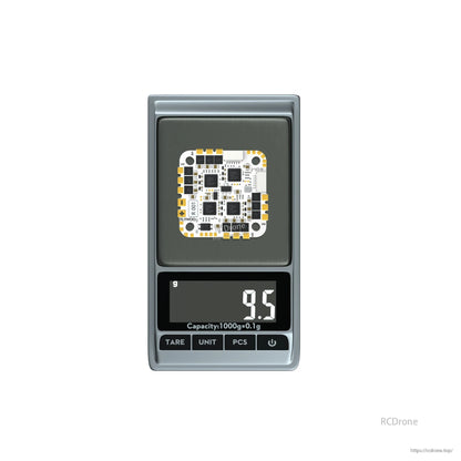Flywoo GOKU GN745 V3 45A AIO flight controller board on a digital scale reading 9.5 g