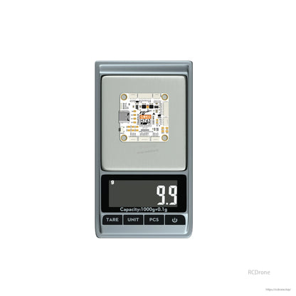 Flywoo GOKU H743 Pro flight controller board on a digital scale, weighing 9.9 g