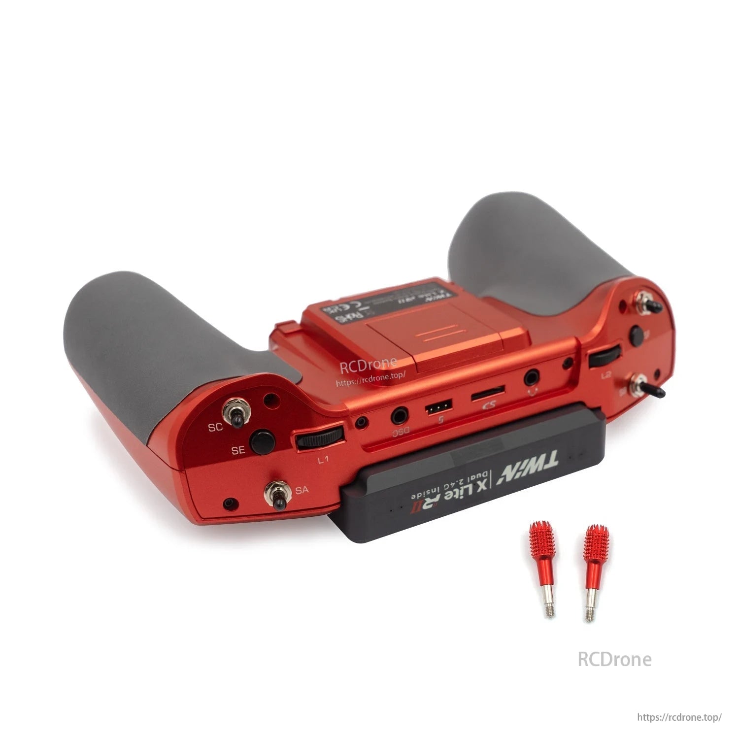 Red transmitter bottom edge close-up showing switches, ports, and included gimbal stick ends