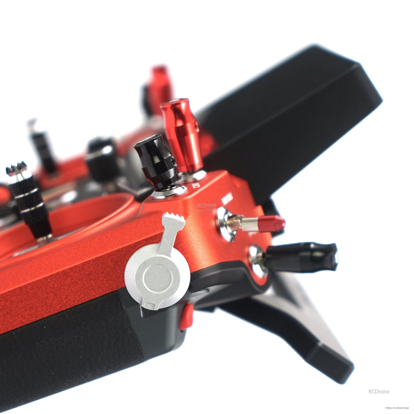 Close-up of FrSky Tandem X20 Pro AeroWing transmitter grip with red anodized body, dial and toggle switches