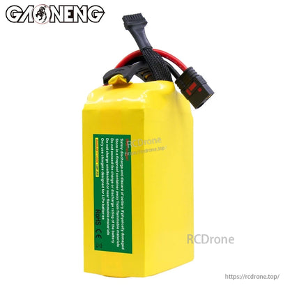 Rear view of battery pack with green safety/compliance label and attached power leads